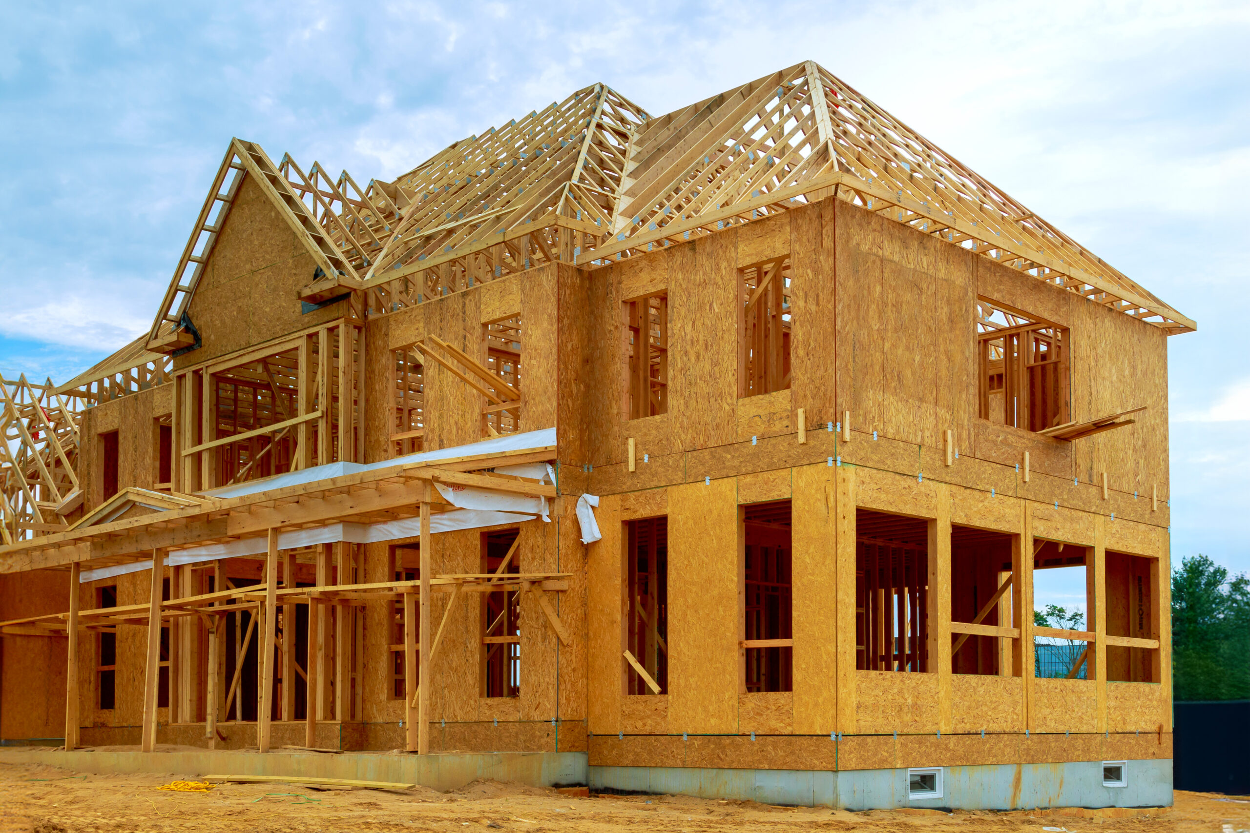 An unfinished interior of newly built house with wood framing supports beam